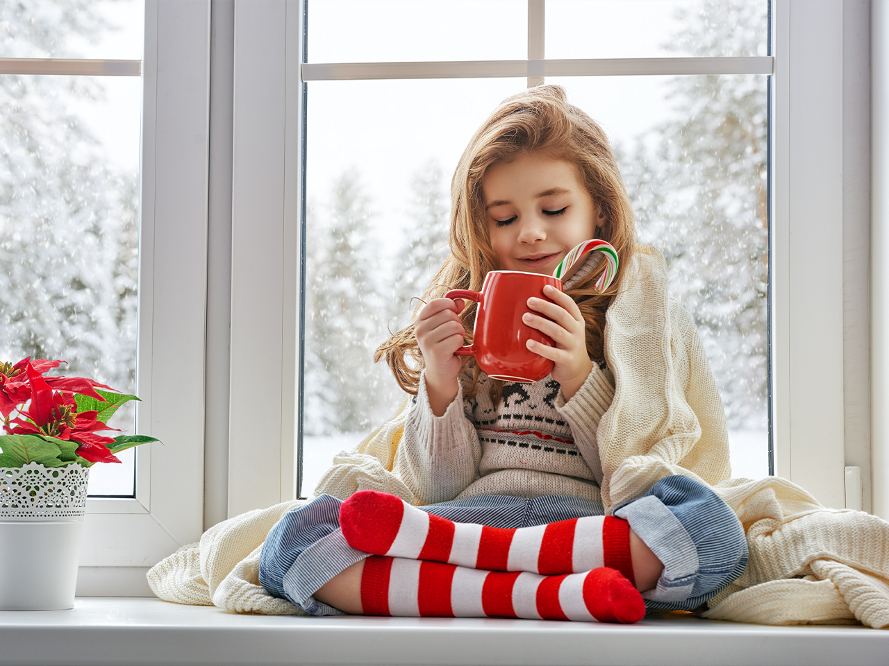 Small Girl With cup in winter on the windowsill